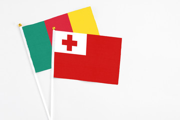 Tonga and Cameroon stick flags on white background. High quality fabric, miniature national flag. Peaceful global concept.White floor for copy space.