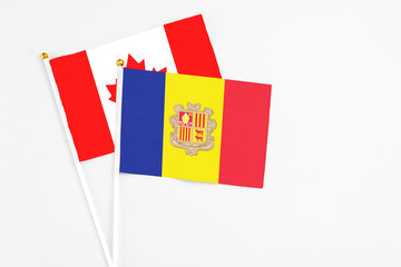 Andorra and Canada stick flags on white background. High quality fabric, miniature national flag. Peaceful global concept.White floor for copy space.