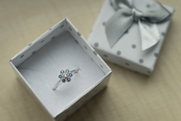 Silver ring with rhinestones in a box.