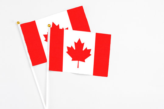 Canada and Canada stick flags on white background. High quality fabric, miniature national flag. Peaceful global concept.White floor for copy space.