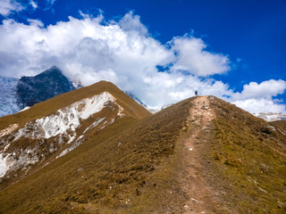 Fototapeta premium Guy hiking towards Upper Kyanjin Ri peak (4800 m.) in Langtang National Park, Nepal.