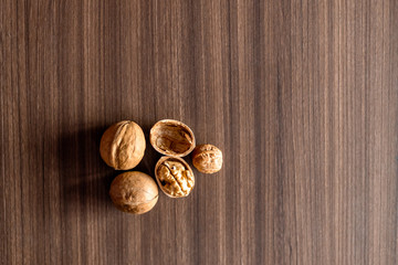 Walnuts kernels on wooden desk with color background, Whole walnut in wood vintage bowl.