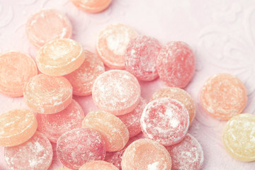 Fruit candy scattered on a pink background, candy in powdered sugar