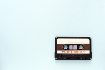 Fototapeta premium Audio tape cassette on a light blue background close-up. Top view