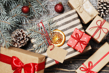 Composition from Christmas tree, gifts on a brown wooden background. Top view. Place for text.