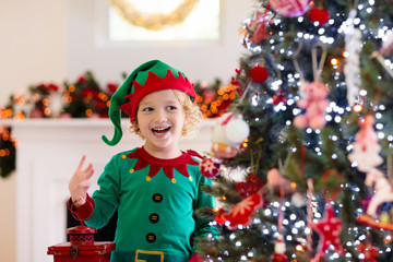 Child decorating Christmas tree. Kid on Xmas eve.