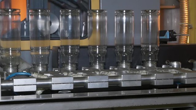 Blown bottles coming out of the mold machine