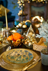 Christmas decorations on a large wooden table. Fir cones and branches are sprinkled with snow and decorated with a garland.