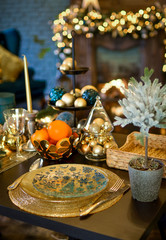 Christmas decorations on a large wooden table. Fir cones and branches are sprinkled with snow and decorated with a garland.