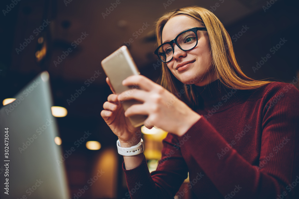 Poster happy hipster girl updating application for creating media files on smartphone device feeling good f