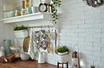 Modern kitchen in white color with a beautiful decor on the shelves. Brickwork in white color, loft style.