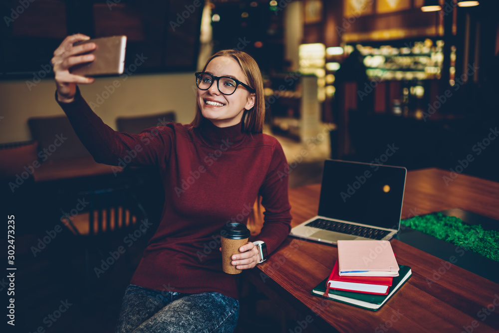 Poster cheerful female blogger taking selfie photos for creating publication on content web page using web 