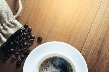 white coffee cup and coffee beans on wooden background. Top view.