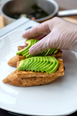 Vegan sandwich with avocado, vegetables and scrambled tofu. Chef cooking. Vegan open sandwiche. Healthy food concept.