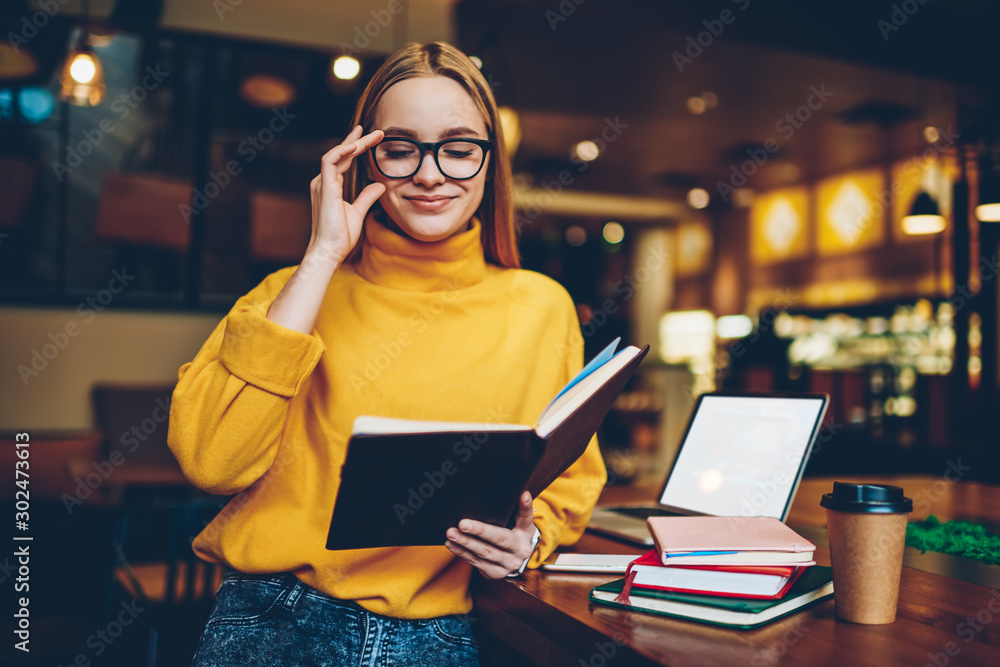 Poster happy female journalist spending time for literature hobby in break of work on computer with mock up