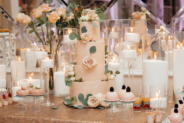 Sweet food on the table. Wedding feast. Catering food, service. Cafeteria, restaurant. Table with desserts and candles. Romantic design. Candy bar. Dessert table for a party. Wedding reception