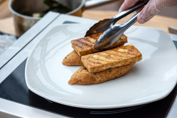 Vegan sandwich with baked marinated tofu with spices. Chef cooking. Vegan open sandwiche. Healthy food concept.