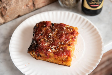 Grandma pizza slice on a paper plate