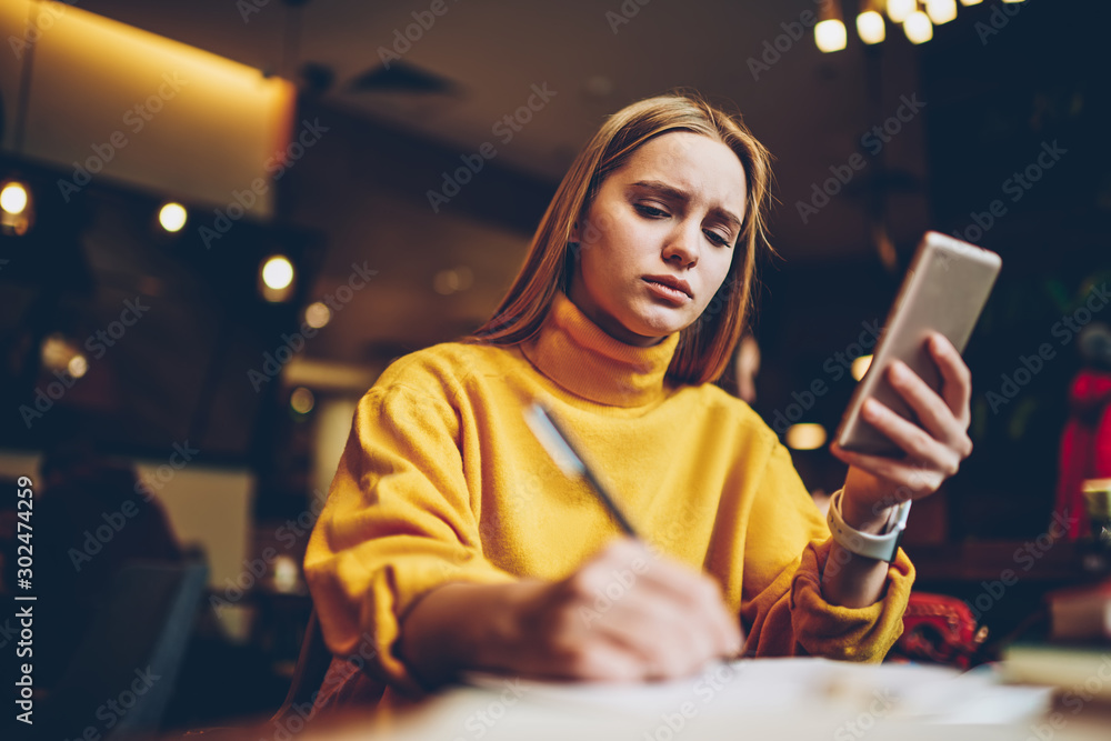 Poster disappointed tired female student preparing for university test writing answers in textbook for educ