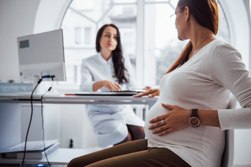 Pregnant woman have consultation with obstetrician indoors