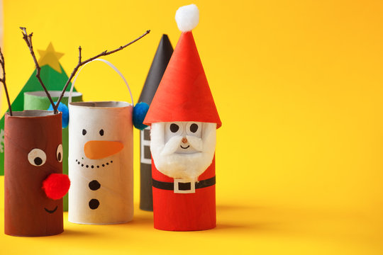 Paper toy santa, snowman, reindeer, grinch, xmas tree for Happy new year Merry Christmas party. Easy crafts for kids on yellow background, idea from toilet rool tube, recycle