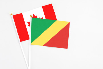 Republic Of The Congo and Canada stick flags on white background. High quality fabric, miniature national flag. Peaceful global concept.White floor for copy space.
