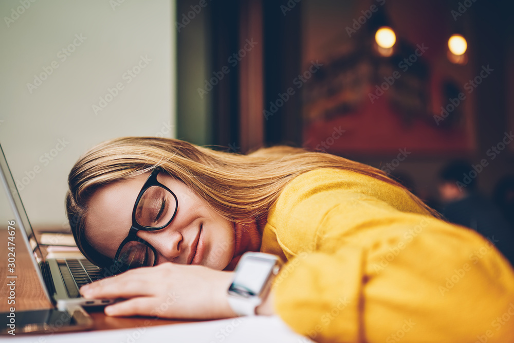 Poster exhausted female student feeling tired after e learning on laptop computer and fall asleep in break 