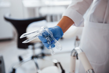 Close up view of female doctor hands that holds speculum instrument