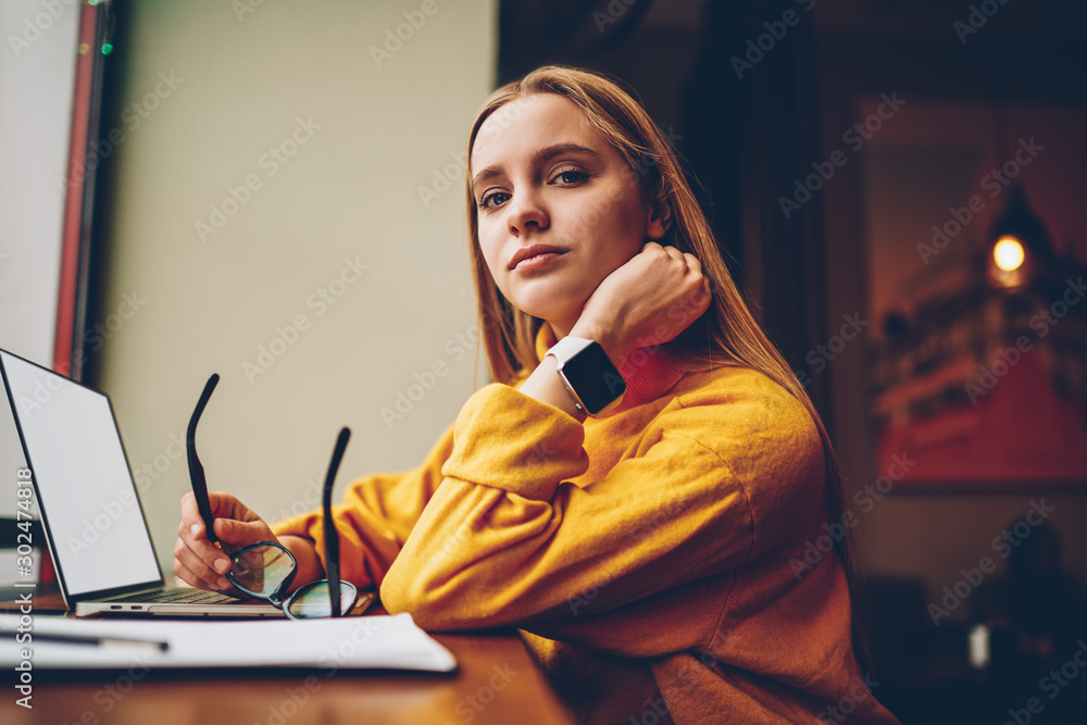 Poster portrait of beautiful female it professional looking at camera after communication with colleagues v