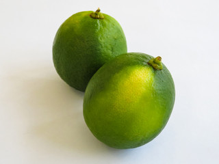 Closeup of two ripe lemons on white background with surface details.