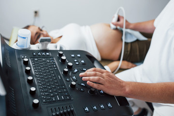 Male doctor does ultrasound for a pregnant woman in the hospital