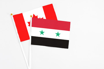 Syria and Canada stick flags on white background. High quality fabric, miniature national flag....