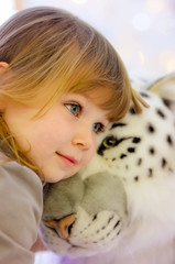 pretty little girl hugging her cuddly toy