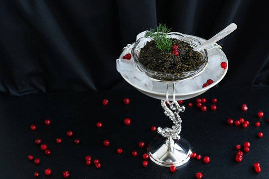 Black caviar in a silver icher with ice. Delicacy. An exquisite gift for the holiday. Food. VIP. Flower. Concept. Free space for text.
