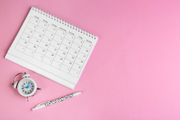 Calender, pen and alarm clock on pink background, flat lay. Space for text