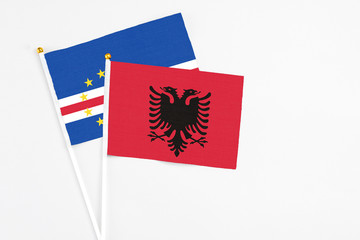 Albania and Cape Verde stick flags on white background. High quality fabric, miniature national flag. Peaceful global concept.White floor for copy space.