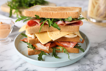 Tasty sandwich with chicken, ham and bacon served on white marble table