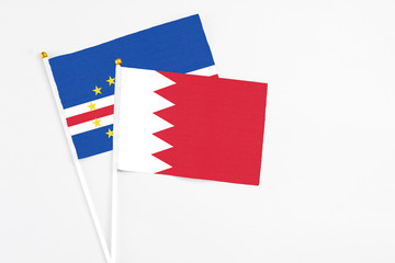 Bahrain and Cape Verde stick flags on white background. High quality fabric, miniature national flag. Peaceful global concept.White floor for copy space.