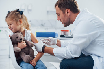 Blood sampling. Little girl is in the clinic with doctor