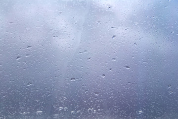 drops of rain on glass window blurred forest background