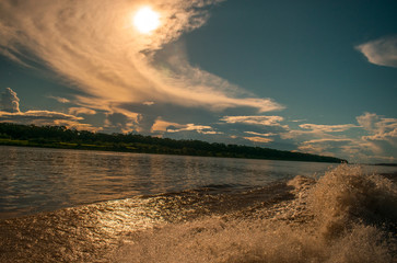 recorrido en medio del  rio amazonas en atardecer 