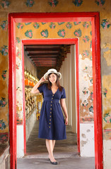 Asian beautiful girl wearing blue dress with white hat travel to Wat Arun in Bangkok, Thailand. Wat Arun is a famous tourist destination of Thailand. Travel concept