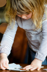 pretty little girl making a puzzle