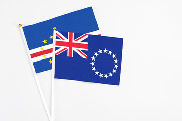 Fototapeta premium Cook Islands and Cape Verde stick flags on white background. High quality fabric, miniature national flag. Peaceful global concept.White floor for copy space.