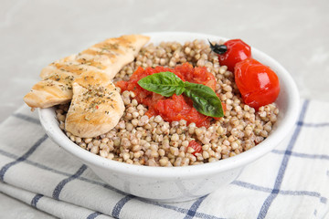 Tasty buckwheat porridge with meat on table, closeup