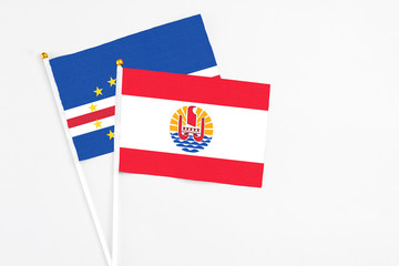 French Polynesia and Cape Verde stick flags on white background. High quality fabric, miniature national flag. Peaceful global concept.White floor for copy space.