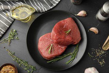 Flat lay composition with fresh beef cut on black table