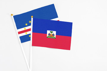Haiti and Cape Verde stick flags on white background. High quality fabric, miniature national flag. Peaceful global concept.White floor for copy space.