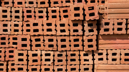 Pile of red clay building bricks background in construction area .