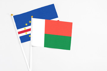Madagascar and Cape Verde stick flags on white background. High quality fabric, miniature national flag. Peaceful global concept.White floor for copy space.